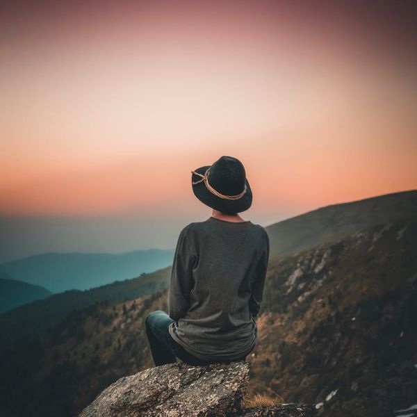 Person meditating outdoors looking serene and energized.
